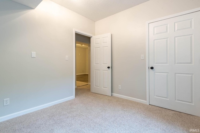 unfurnished bedroom with a textured ceiling and light carpet