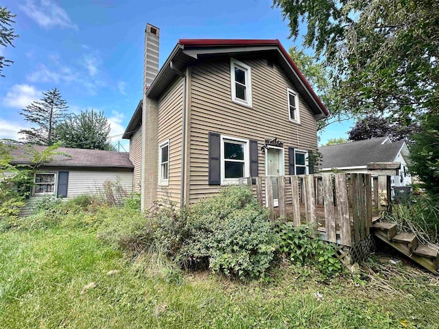 rear view of house featuring a wooden deck