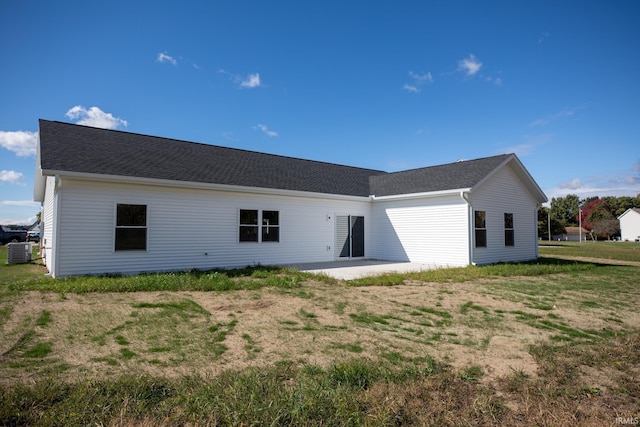 back of house with cooling unit, a patio area, and a lawn