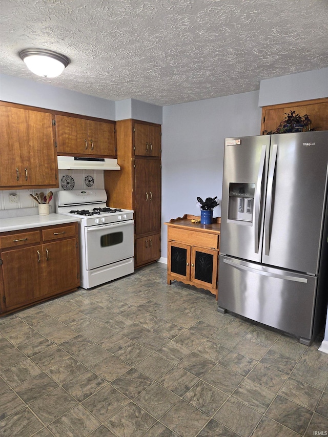 kitchen featuring stainless steel fridge, a textured ceiling, and white gas range