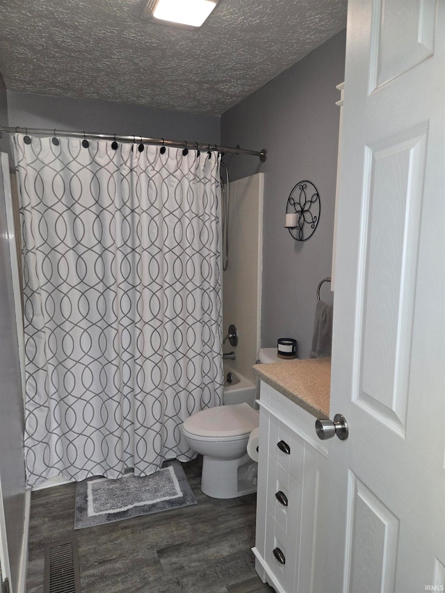 full bathroom featuring a textured ceiling, vanity, shower / tub combo with curtain, toilet, and hardwood / wood-style flooring