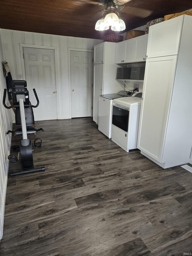 kitchen with dark wood-type flooring, ceiling fan, white cabinetry, and washer and dryer