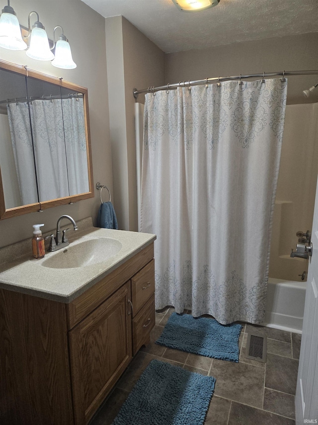 full bath featuring shower / bathtub combination with curtain, visible vents, a textured ceiling, and vanity