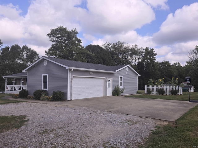 view of side of home with concrete driveway, fence, and an attached garage