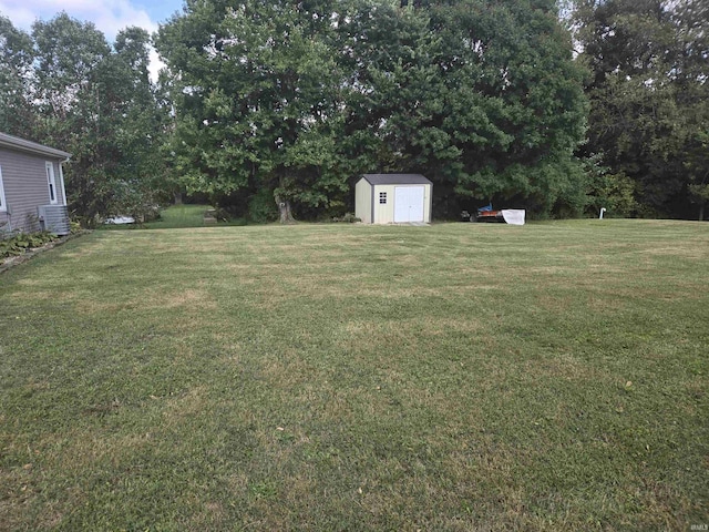 view of yard with central AC unit, a shed, and an outdoor structure