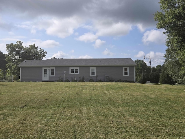 rear view of property featuring a lawn