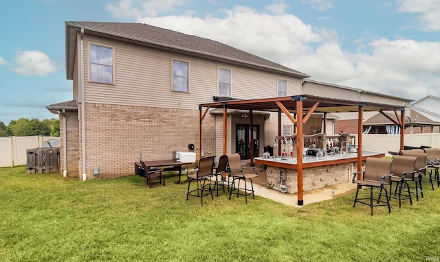 back of house featuring a yard and an outdoor bar