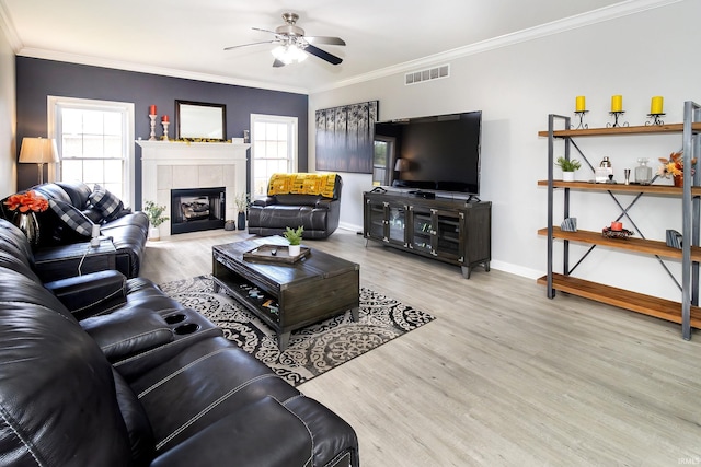 living room featuring crown molding, plenty of natural light, and light hardwood / wood-style floors