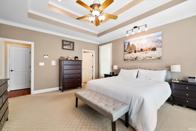 carpeted bedroom featuring ceiling fan, a raised ceiling, and ornamental molding