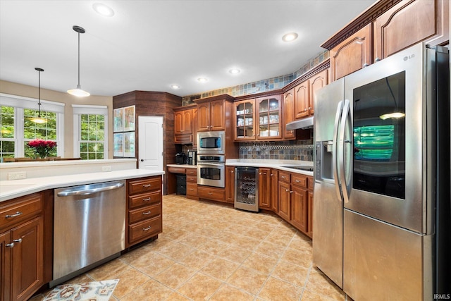 kitchen featuring backsplash, light tile patterned floors, appliances with stainless steel finishes, wine cooler, and pendant lighting