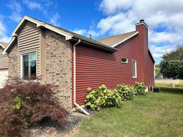 view of side of home with a yard and central AC unit