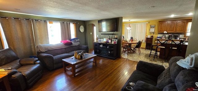 living room featuring a textured ceiling and dark hardwood / wood-style floors