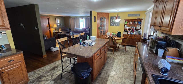 kitchen featuring dark stone counters, a breakfast bar, a kitchen island, and dark hardwood / wood-style floors