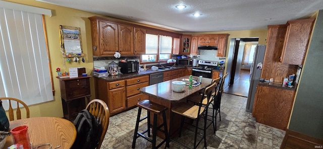 kitchen featuring a textured ceiling, stainless steel appliances, and sink