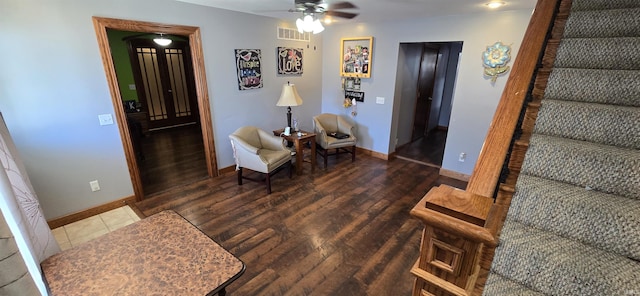 sitting room with visible vents, stairway, baseboards, and wood finished floors