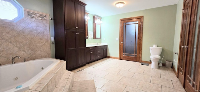 bathroom featuring tile patterned flooring, vanity, tiled tub, and toilet