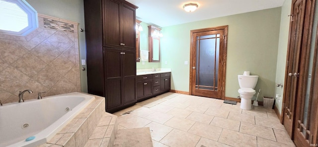 full bath with toilet, vanity, baseboards, a jetted tub, and tile patterned floors