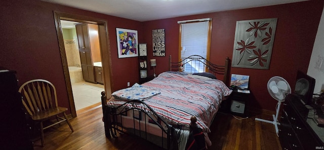 bedroom with ensuite bath and dark wood-type flooring