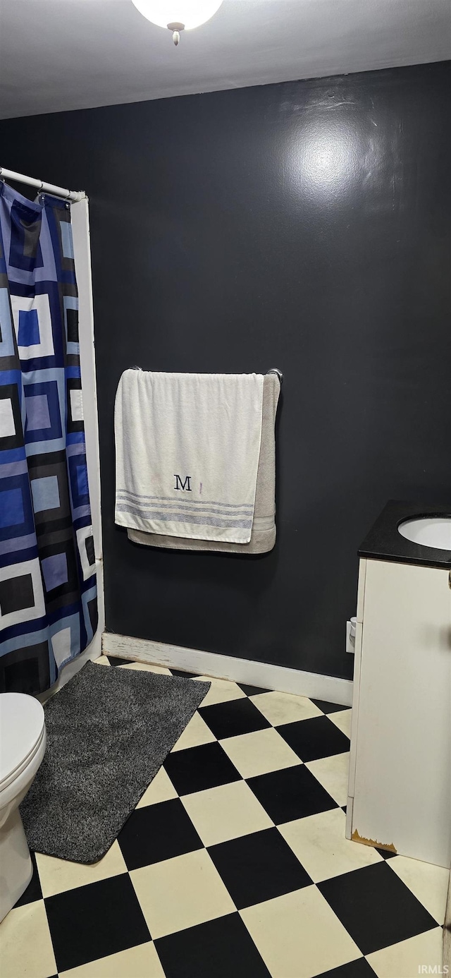 bathroom featuring toilet, curtained shower, vanity, and tile patterned floors