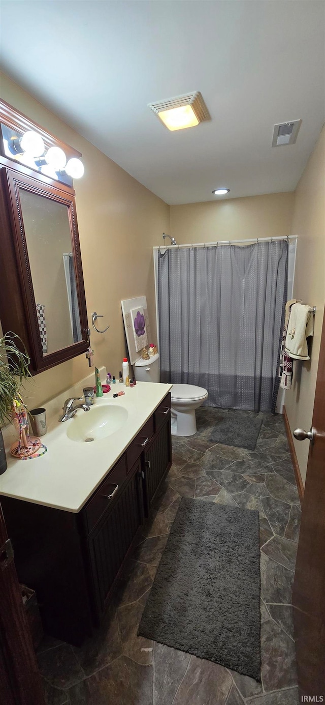 bathroom with vanity, toilet, and curtained shower