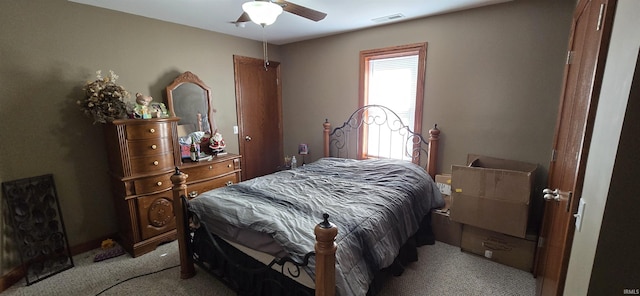 bedroom featuring visible vents, a ceiling fan, and light colored carpet