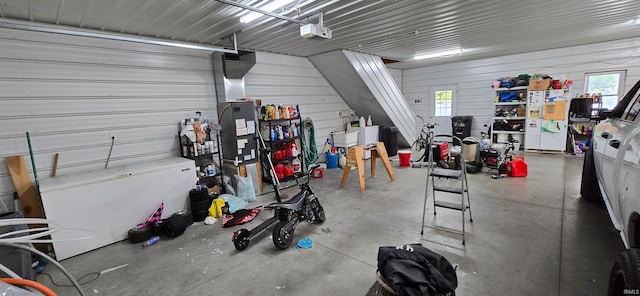 garage with a garage door opener and white fridge with ice dispenser