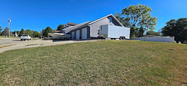 view of side of property featuring a lawn and a garage