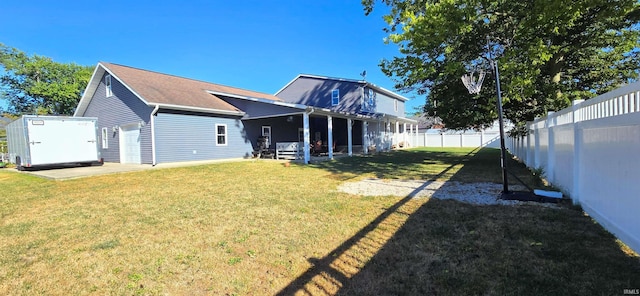 back of house featuring a fenced backyard, a yard, and a patio