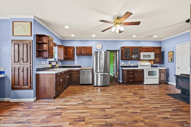 kitchen with ornamental molding, appliances with stainless steel finishes, hardwood / wood-style floors, and ceiling fan