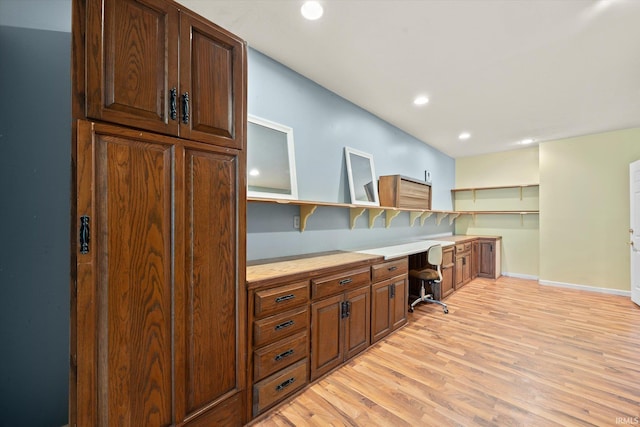 kitchen featuring built in desk and light hardwood / wood-style floors