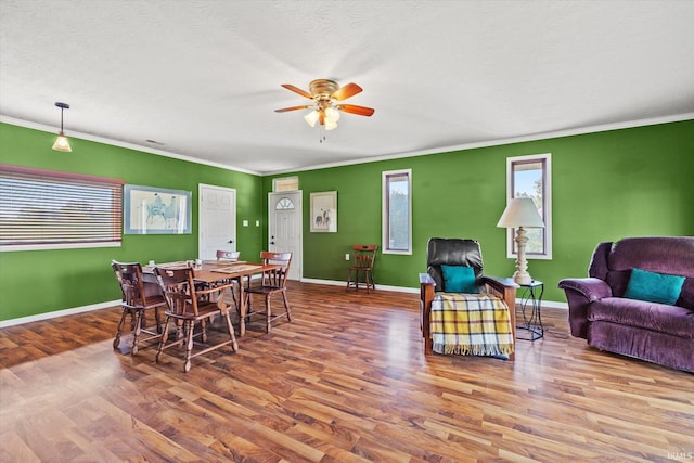 dining space featuring a textured ceiling, ceiling fan, ornamental molding, and hardwood / wood-style floors