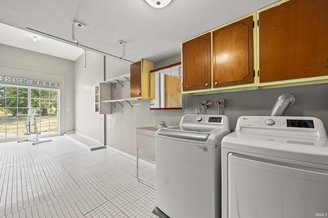 washroom with cabinets and washer and clothes dryer