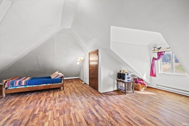 additional living space featuring baseboard heating, vaulted ceiling, and wood-type flooring