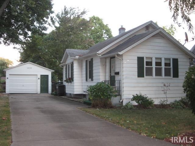 bungalow-style home with a garage and an outbuilding