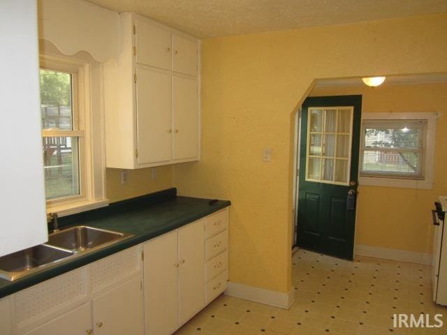 kitchen featuring white cabinets, a textured ceiling, and sink