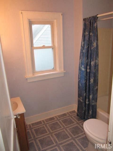 full bathroom with shower / bath combo with shower curtain, toilet, and vanity