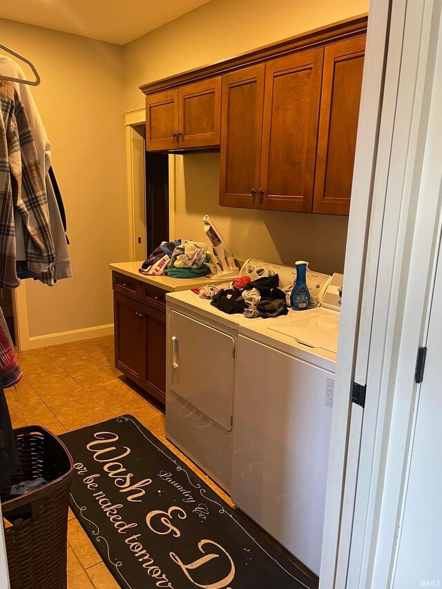 washroom featuring light tile patterned floors, cabinets, and washer and dryer