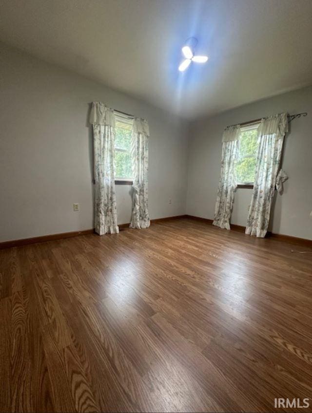 spare room featuring a wealth of natural light and dark hardwood / wood-style flooring