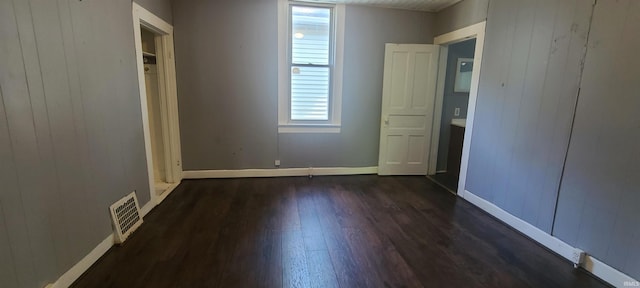 unfurnished bedroom featuring dark wood-type flooring and a closet