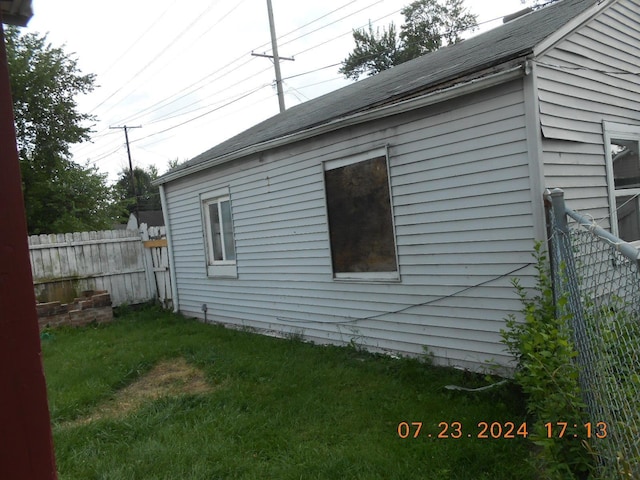 view of side of property featuring a yard and fence