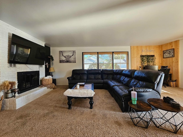 carpeted living room featuring wood walls and a fireplace