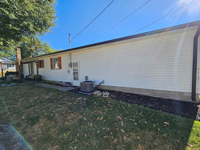 rear view of property with a lawn and central air condition unit