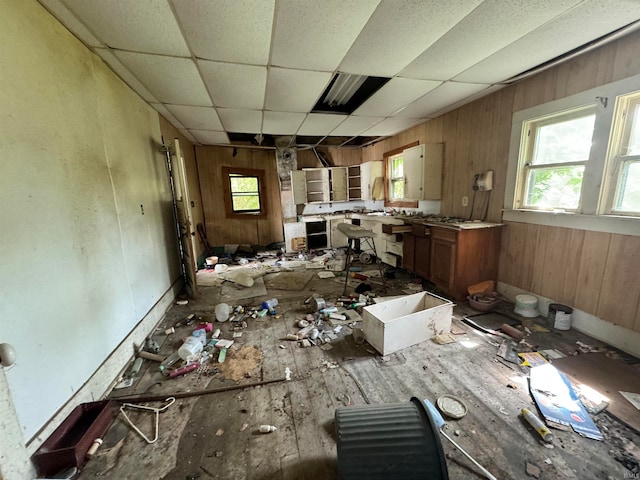 miscellaneous room with a paneled ceiling, wood-type flooring, and wooden walls