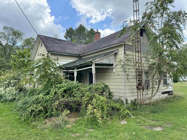 view of side of home with a yard