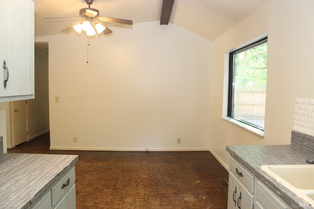 interior space featuring ceiling fan, lofted ceiling with beams, and sink