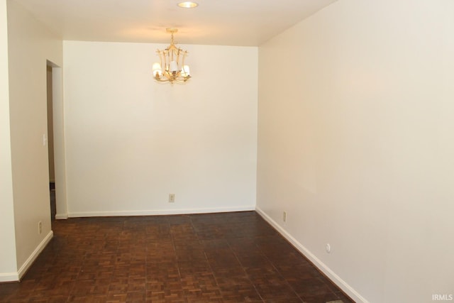 spare room featuring an inviting chandelier