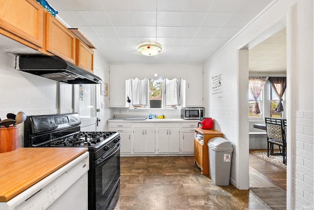 kitchen with white dishwasher, sink, gas stove, and white cabinets