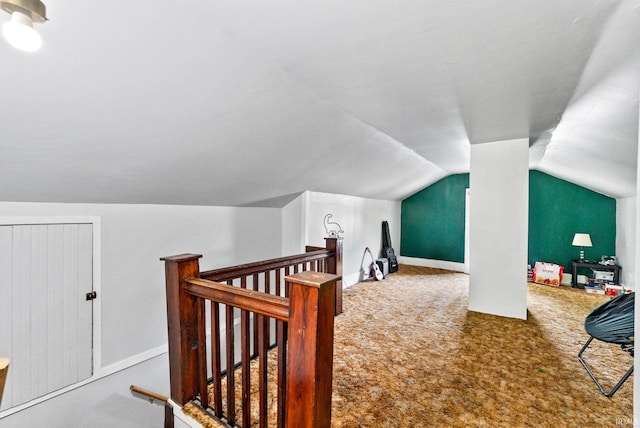 bonus room with vaulted ceiling and carpet flooring