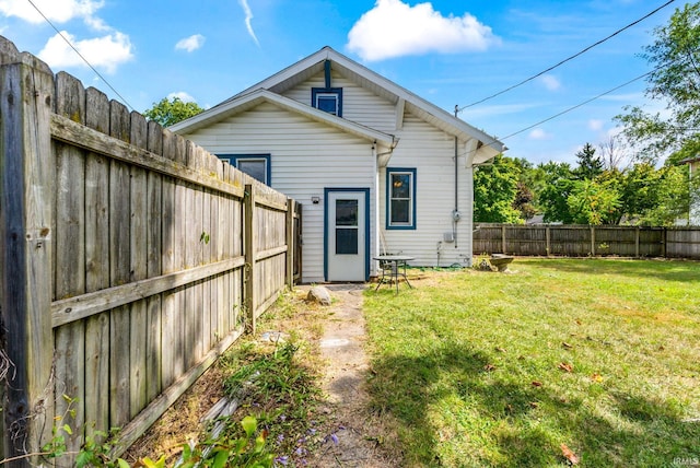 back of house featuring a lawn