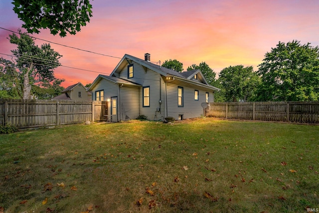 back house at dusk with a yard